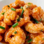 Close-up of bang bang shrimp piled high, garnished with green onions.