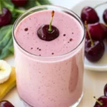 Fresh Cherry Smoothie Recipe with banana and spinach on a wooden table.