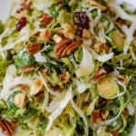 Close-up of a vibrant & tasty brussel sprout salad. Includes shaved sprouts, pecans & cranberries. A fresh, healthy dish!