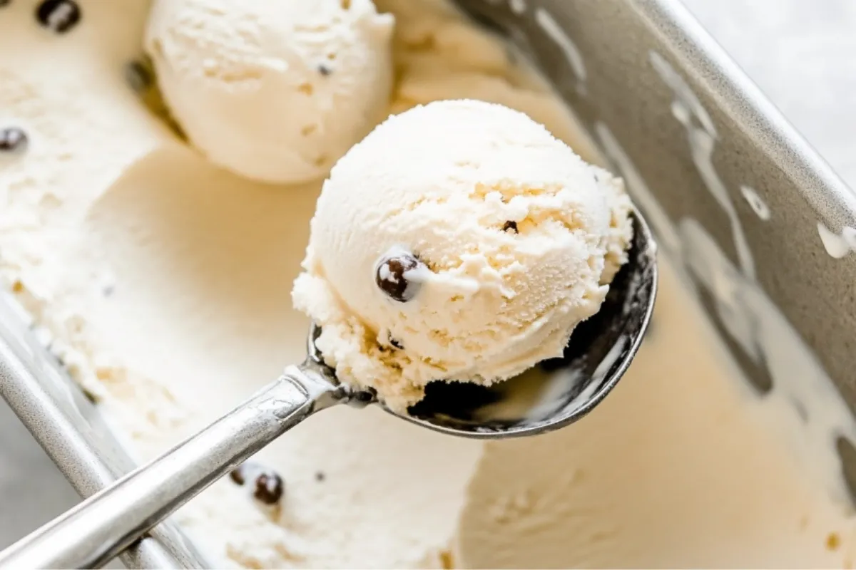 Scooping cottage cheese ice cream from a container.