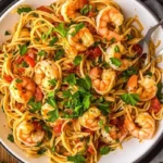 Overhead view of delicious shrimp fra diavolo on linguine with parsley garnish, red pepper flakes.