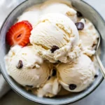 Cottage cheese ice cream with sliced strawberries in a glass bowl.